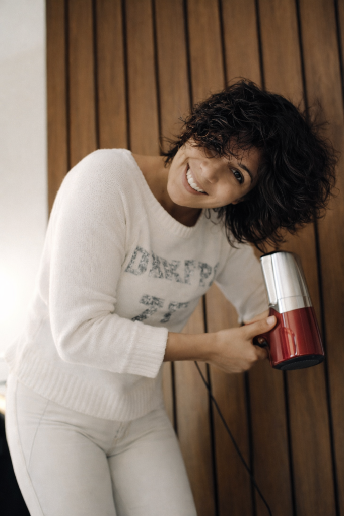 Mulher sorridente a secar o cabelo