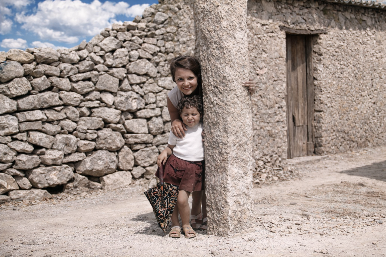 Mulher e criança à sombra da coluna