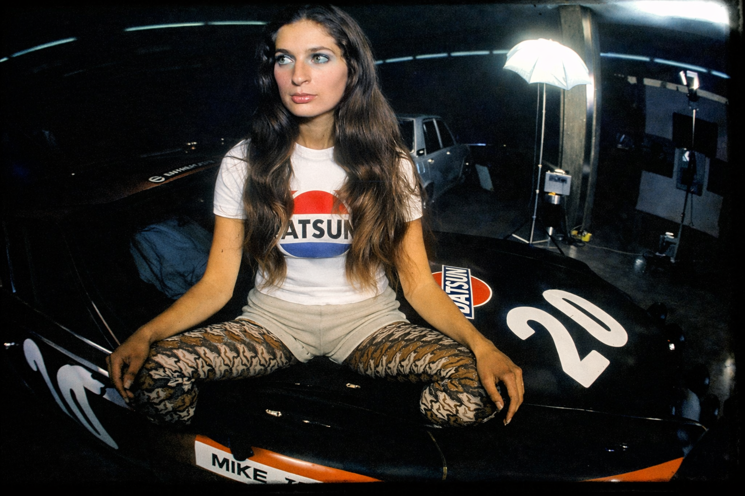 Mulher e Datsun numa garagem vintage