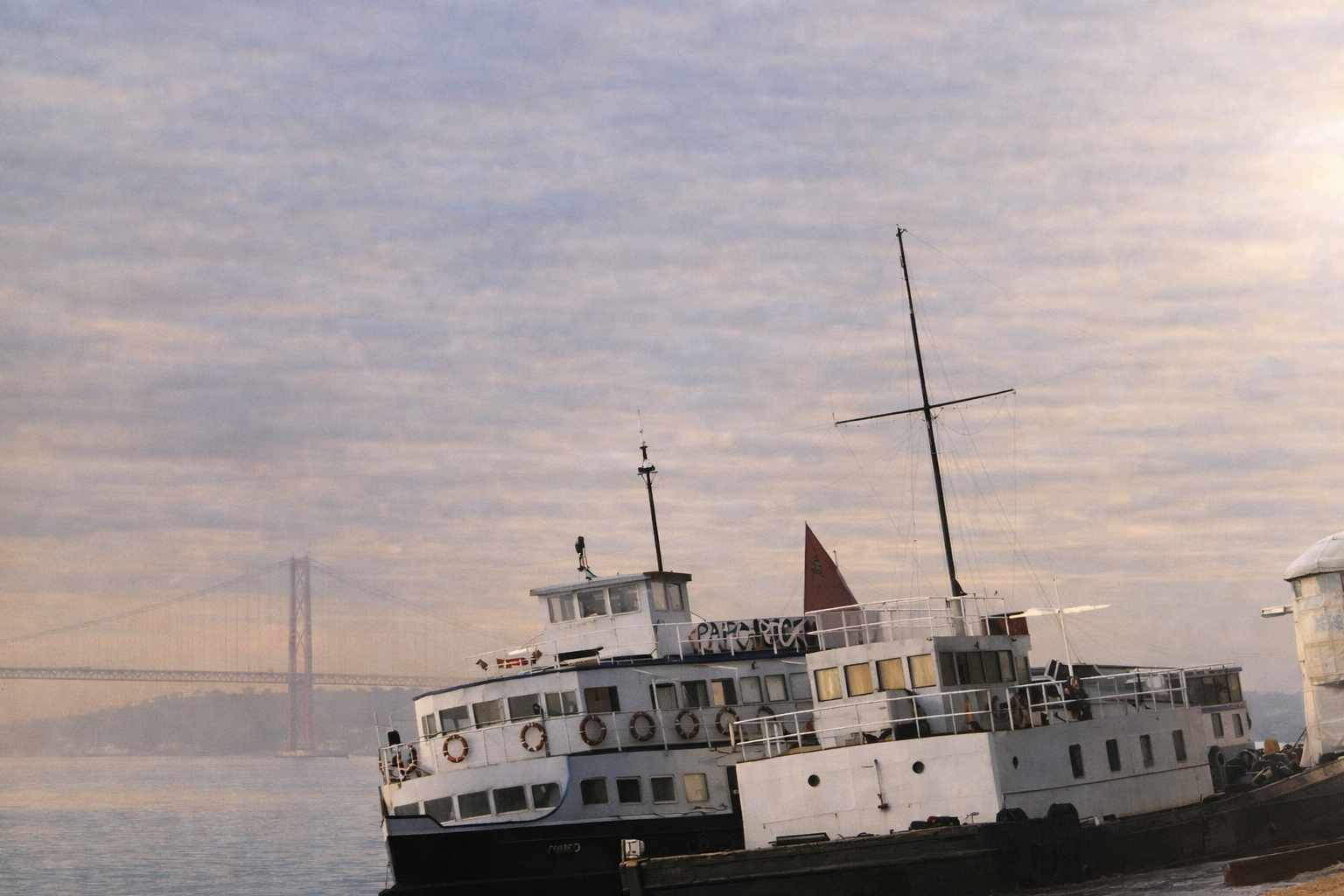 Ferry ao amanhecer com ponte ao fundo