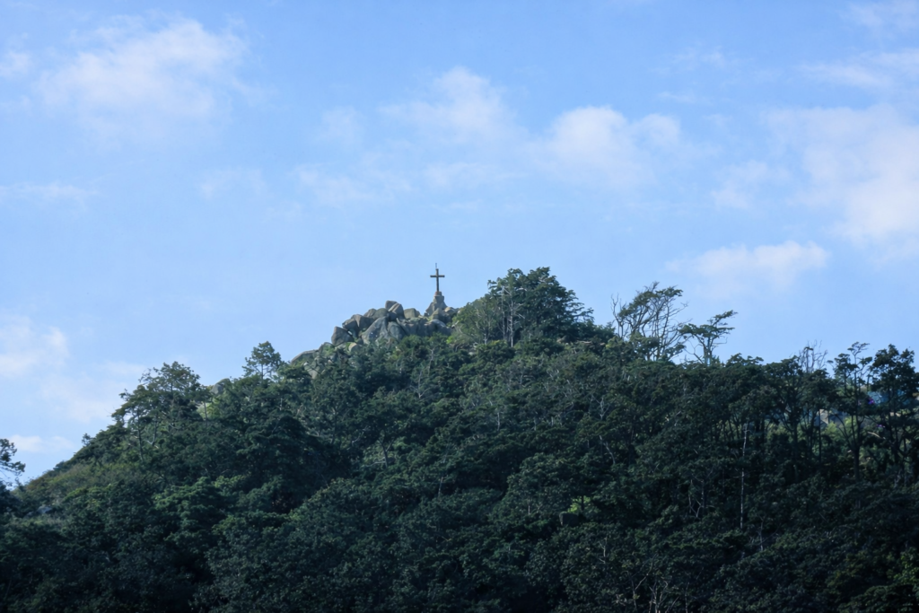 Colina verde com cruz no topo