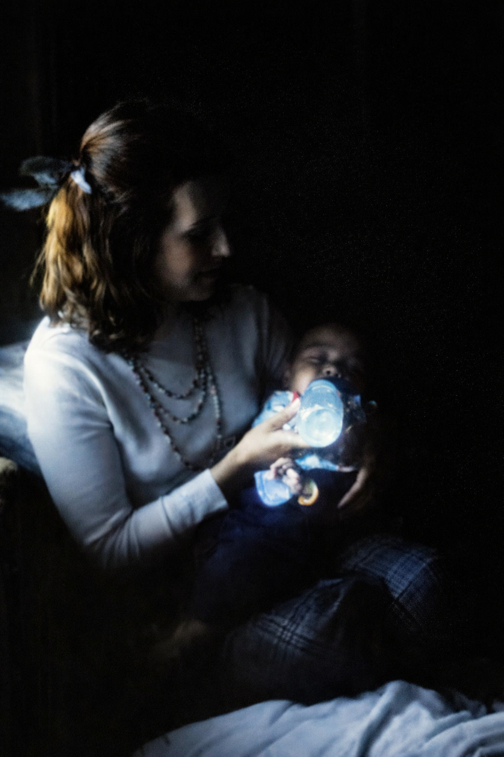 Mãe alimentando o bebé à noite