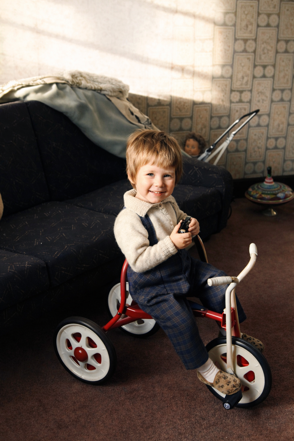 Menino sorridente na triciclo vermelho