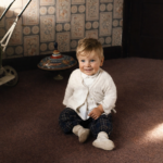 Menino sorridente no chão da sala