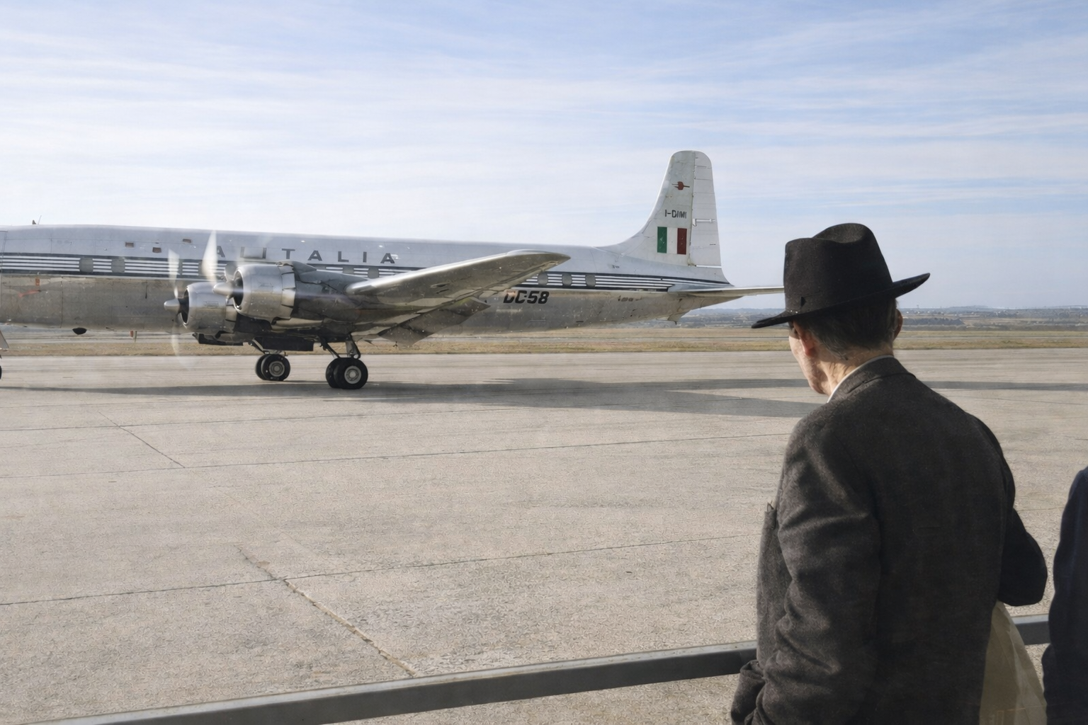Homem observa aeronave da Alitalia