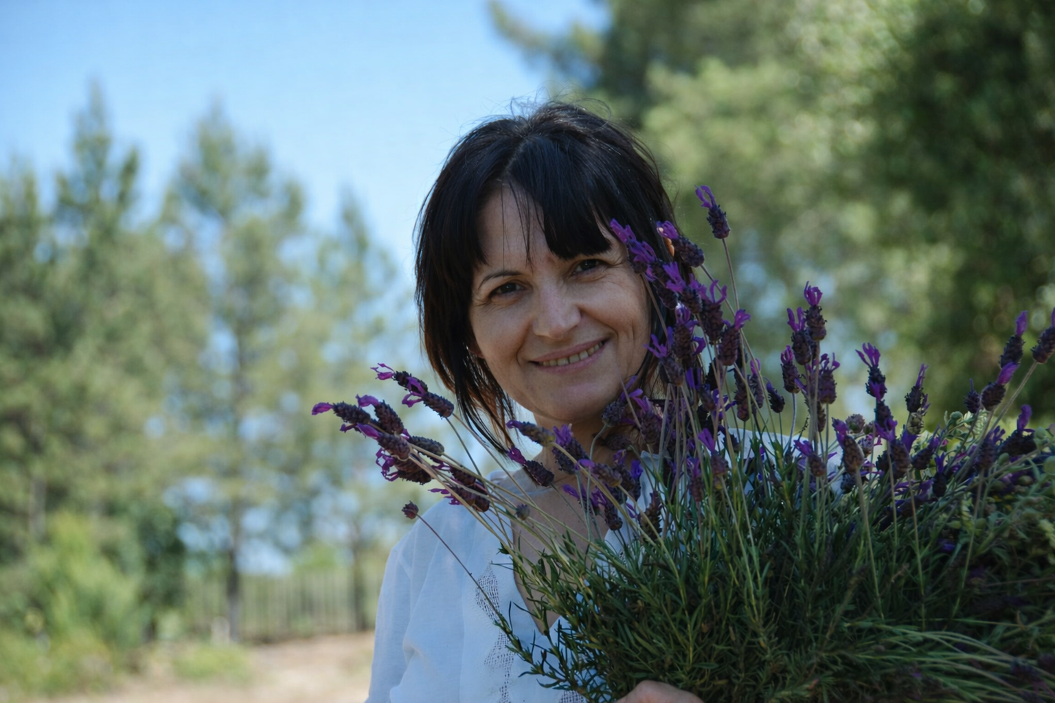 Mulher com ramo de lavanda ao sol