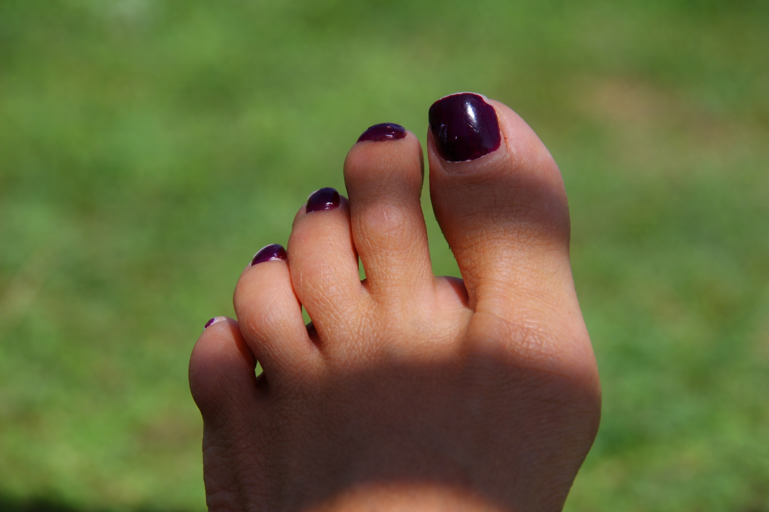 Dedos com esmalte roxo brilhante