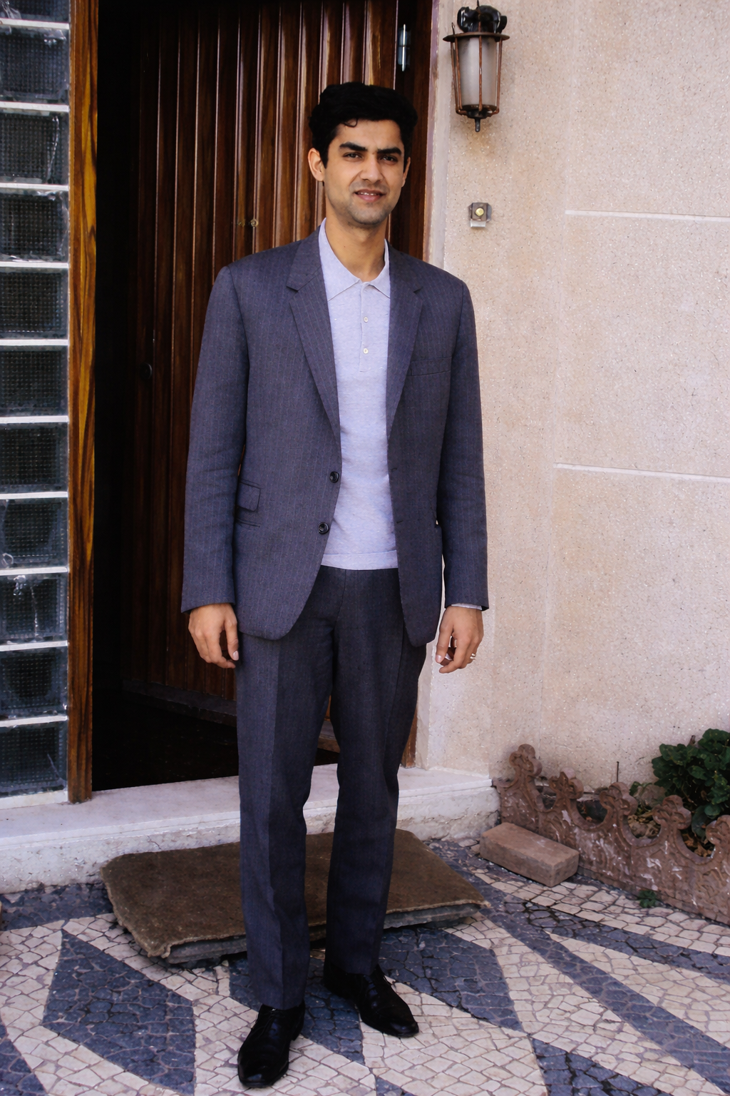 Homem elegante em frente à porta de madeira