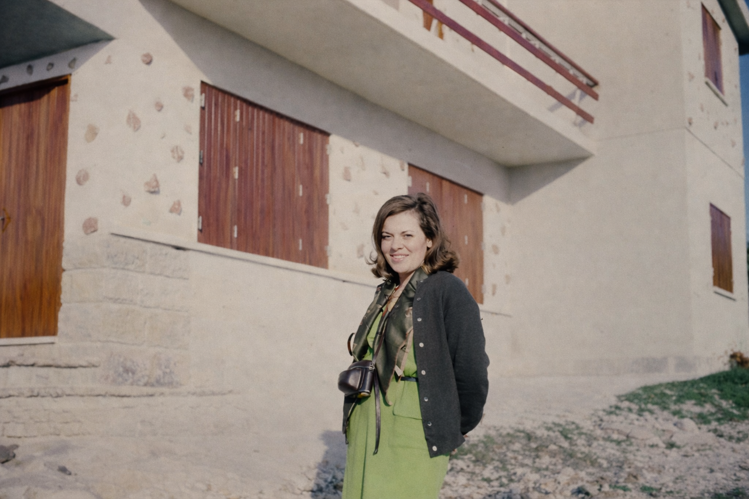 Mulher sorridente em frente à casa