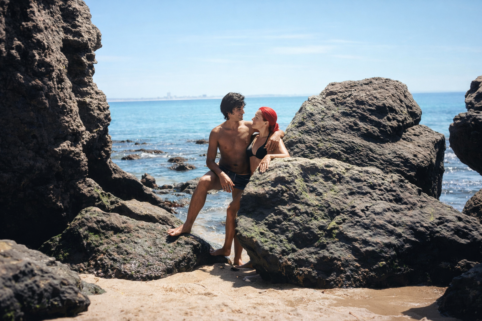 Casal à beira-mar entre rochas