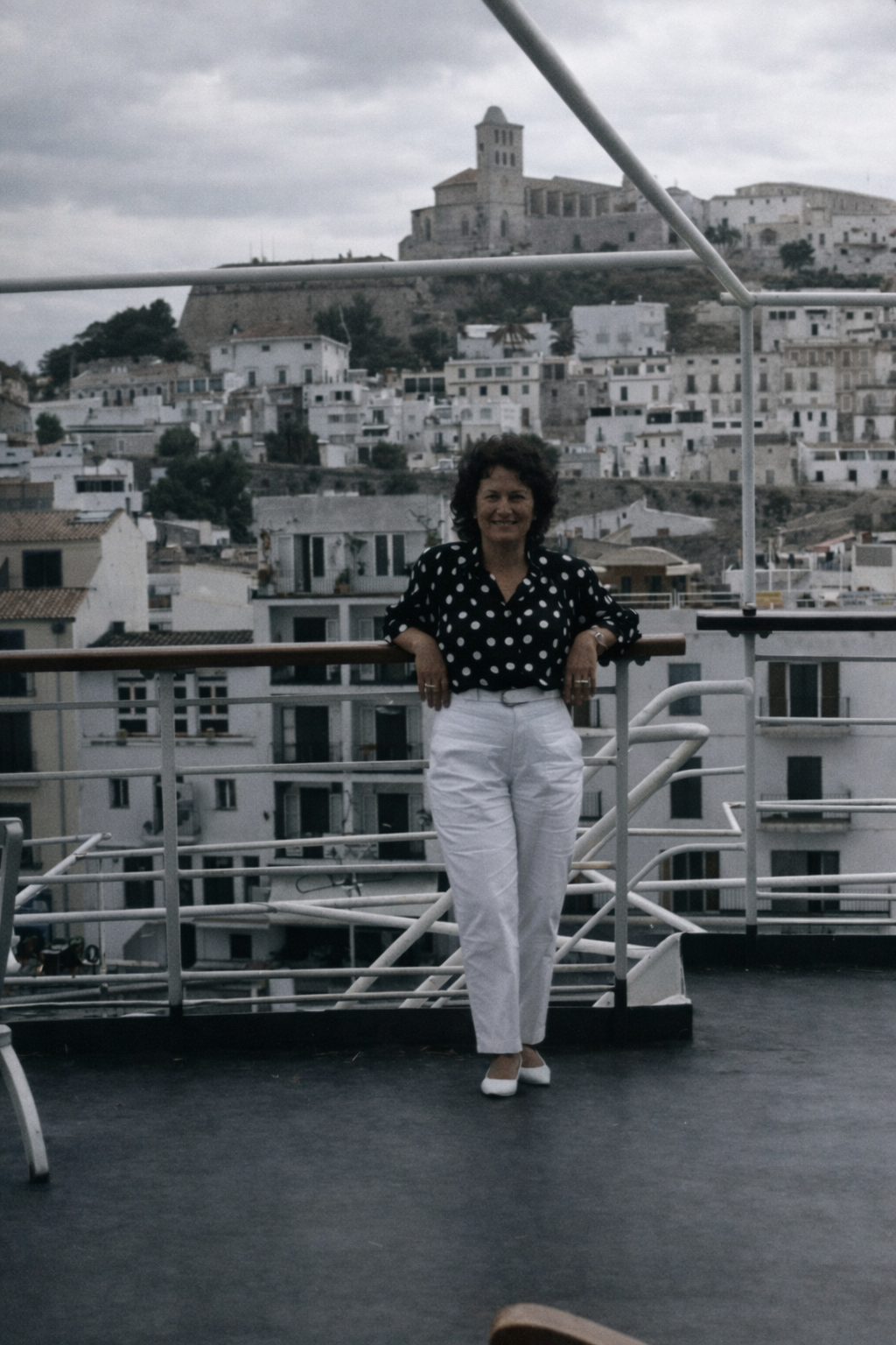 Mulher sorridente numa varanda urbana