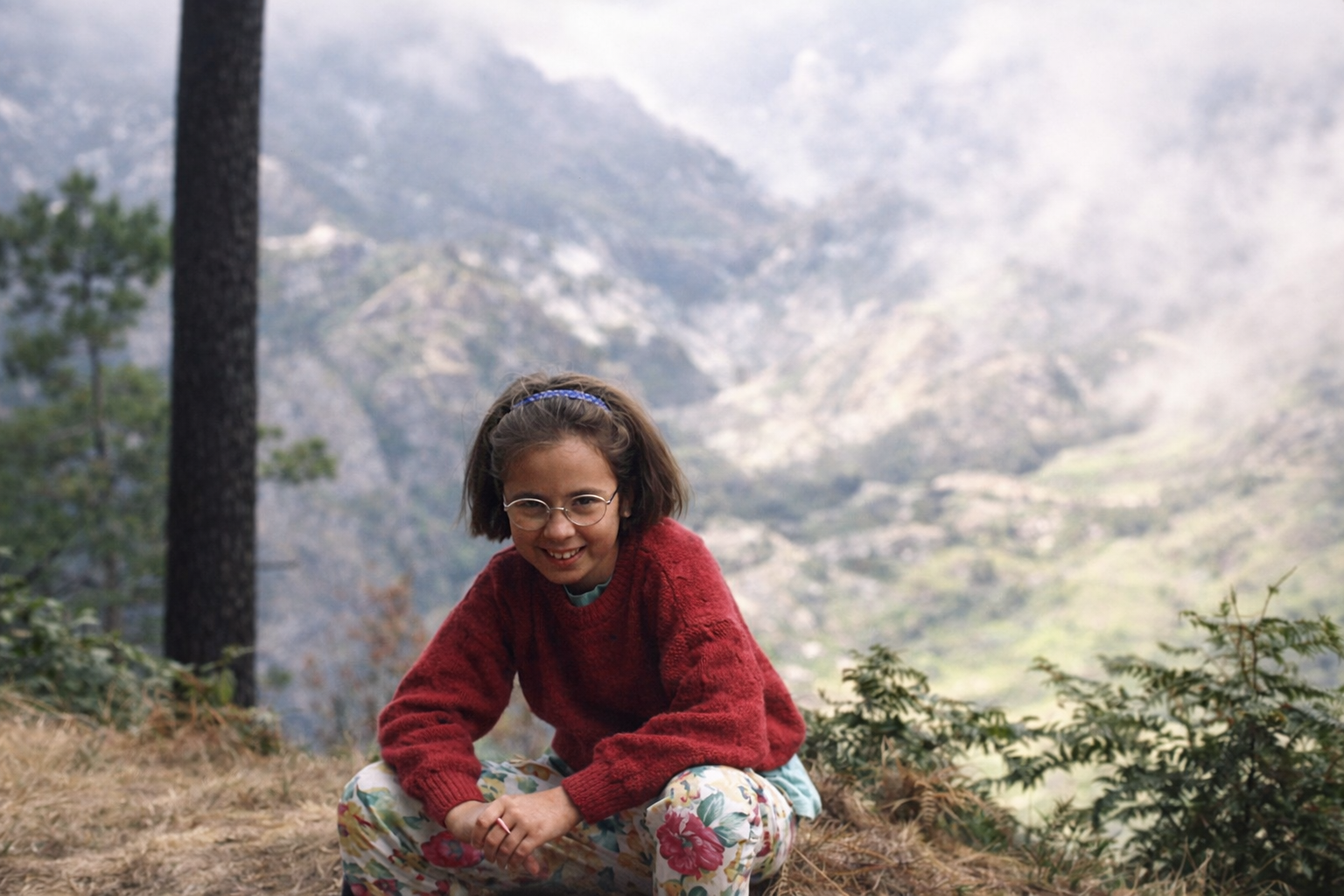 Garota sorridente na montanha nevoenta