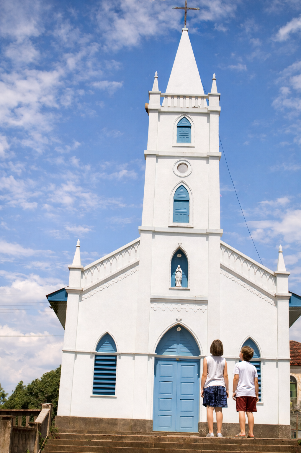 Igreja branca com crianças no topo da escada