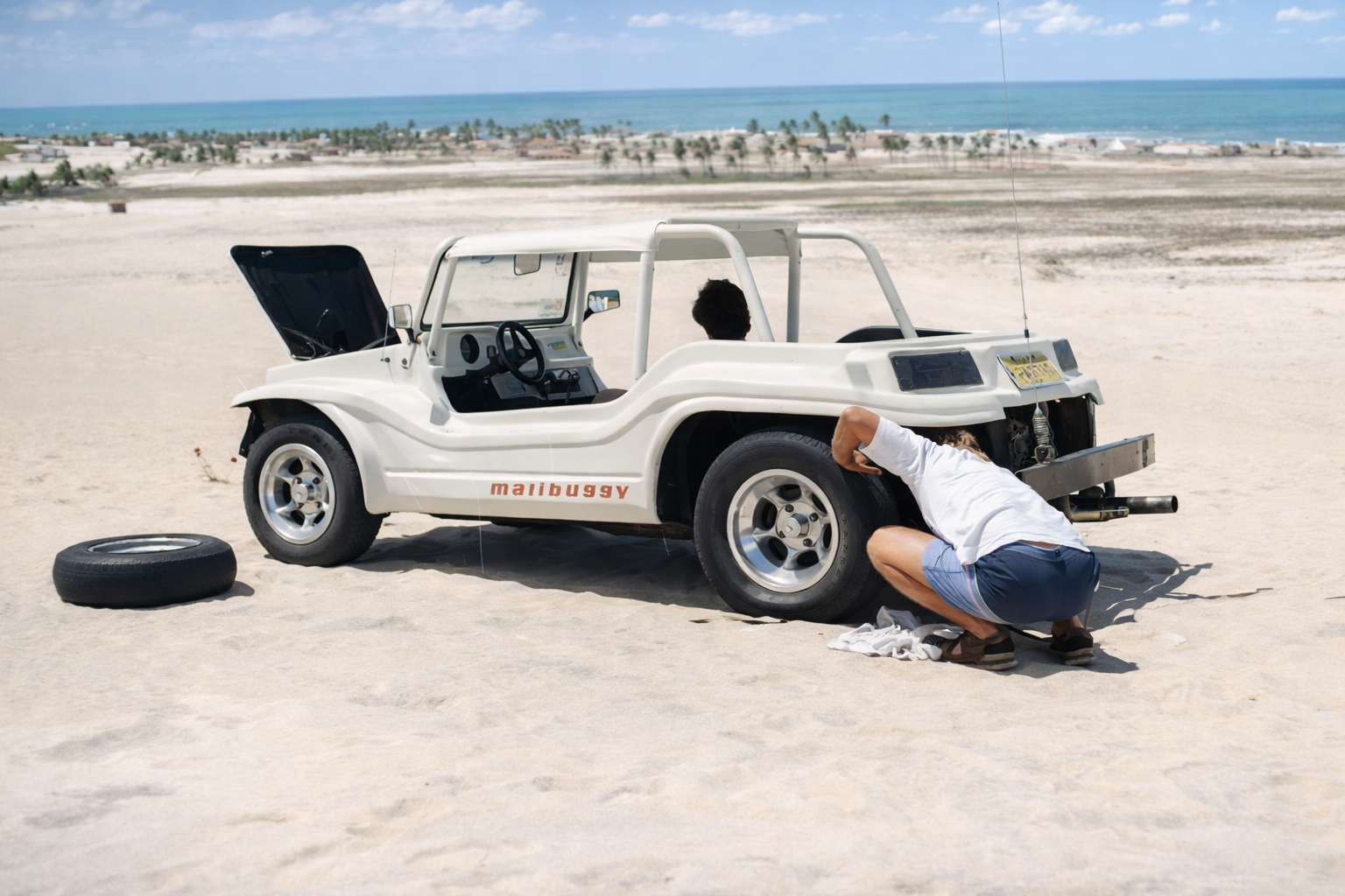 Homem na praia a reparar o buggy