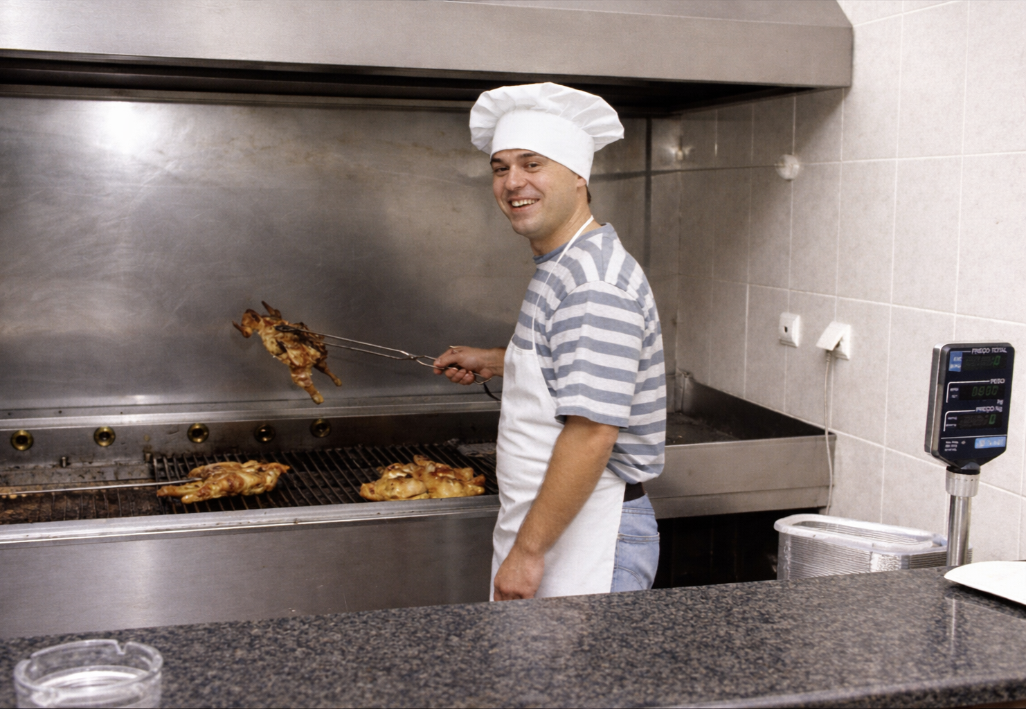 Chef a grelhar frango na cozinha