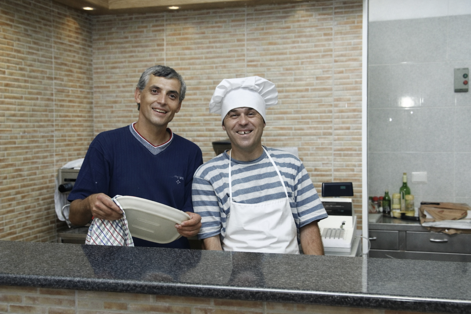 Homem de t-shirt e chef na cozinha