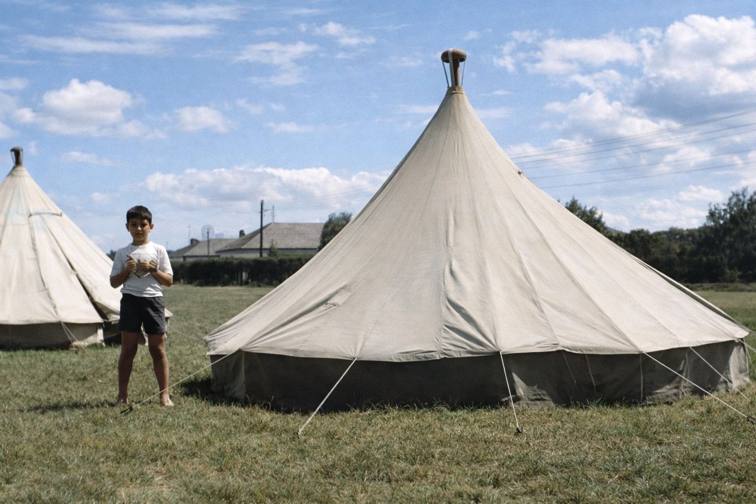 Rapaz junto à tenda no campo