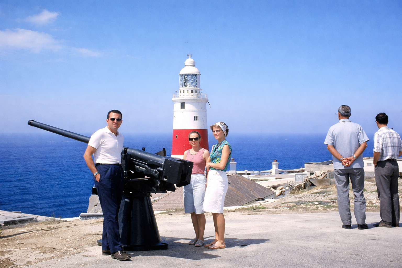 Turistas no farol à beira-mar