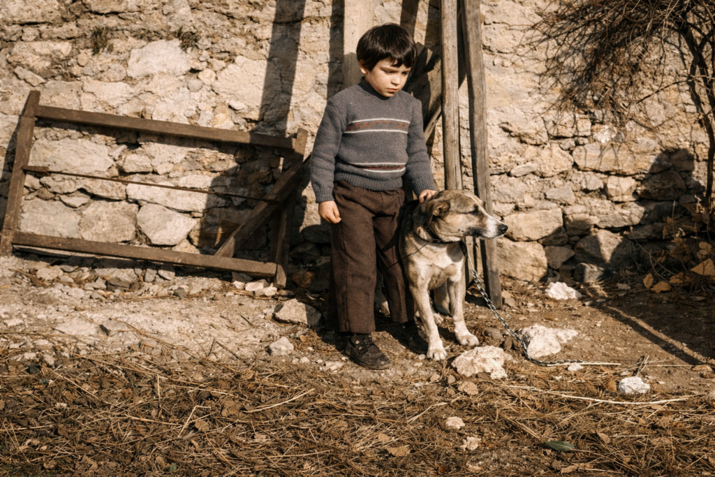Menino e cão em cenário rústico