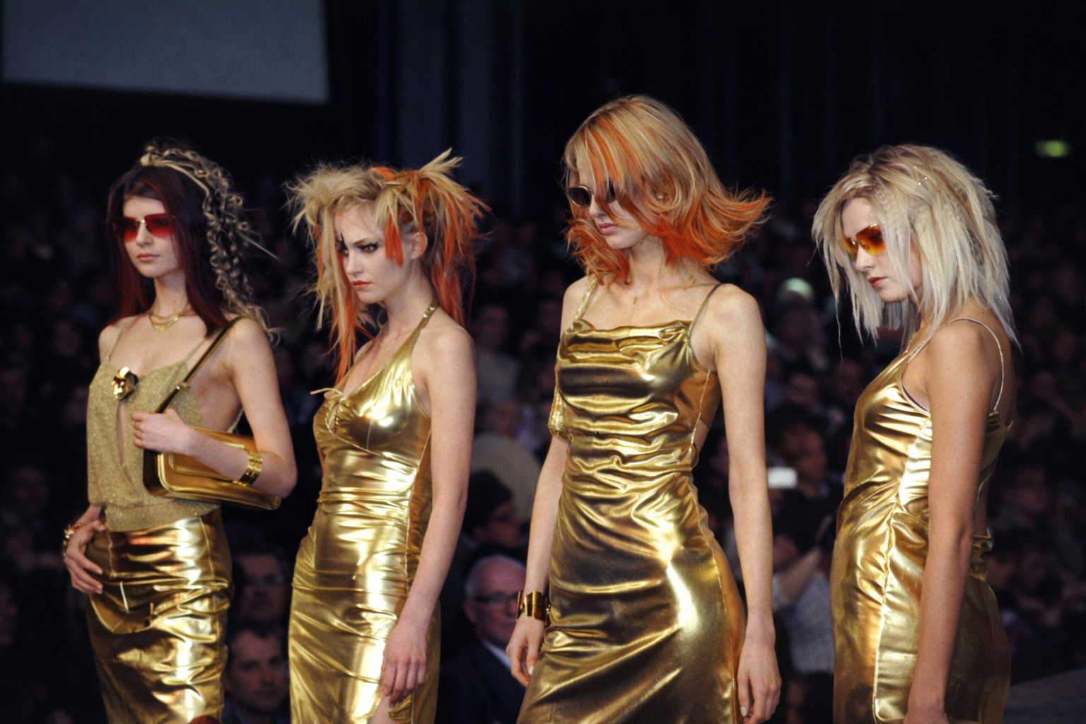 Desfile de modelos com vestidos dourados