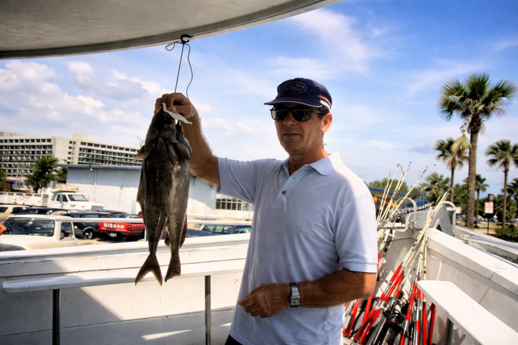 Homem no barco com grande peixe