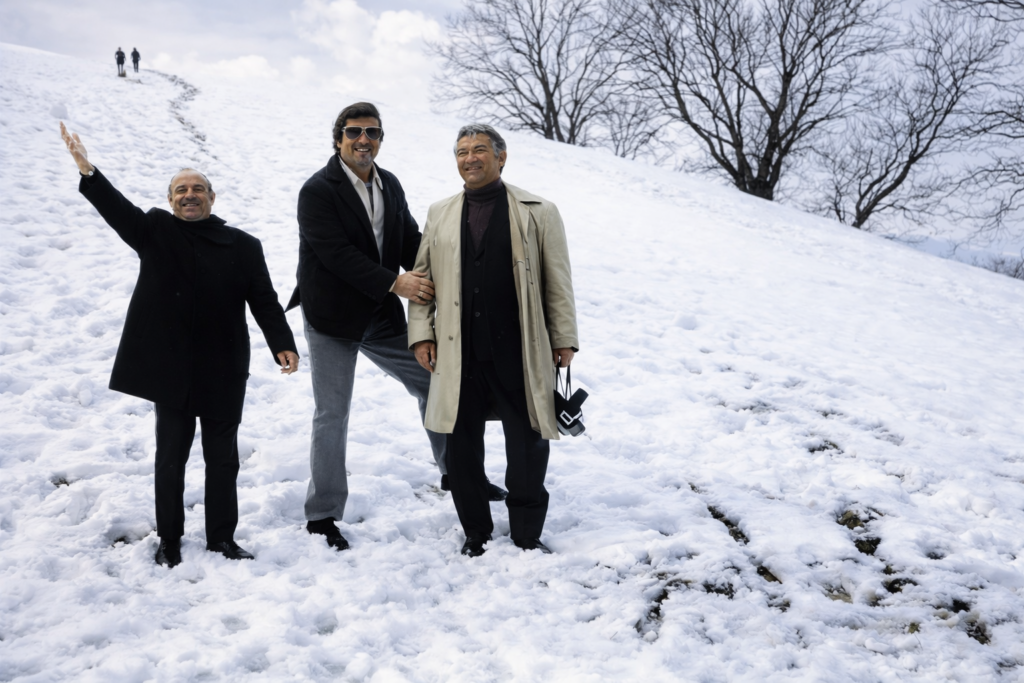 Homens sorridentes na colina coberta de neve