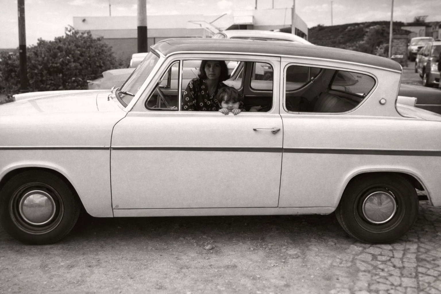 Mulher e criança em carro antigo