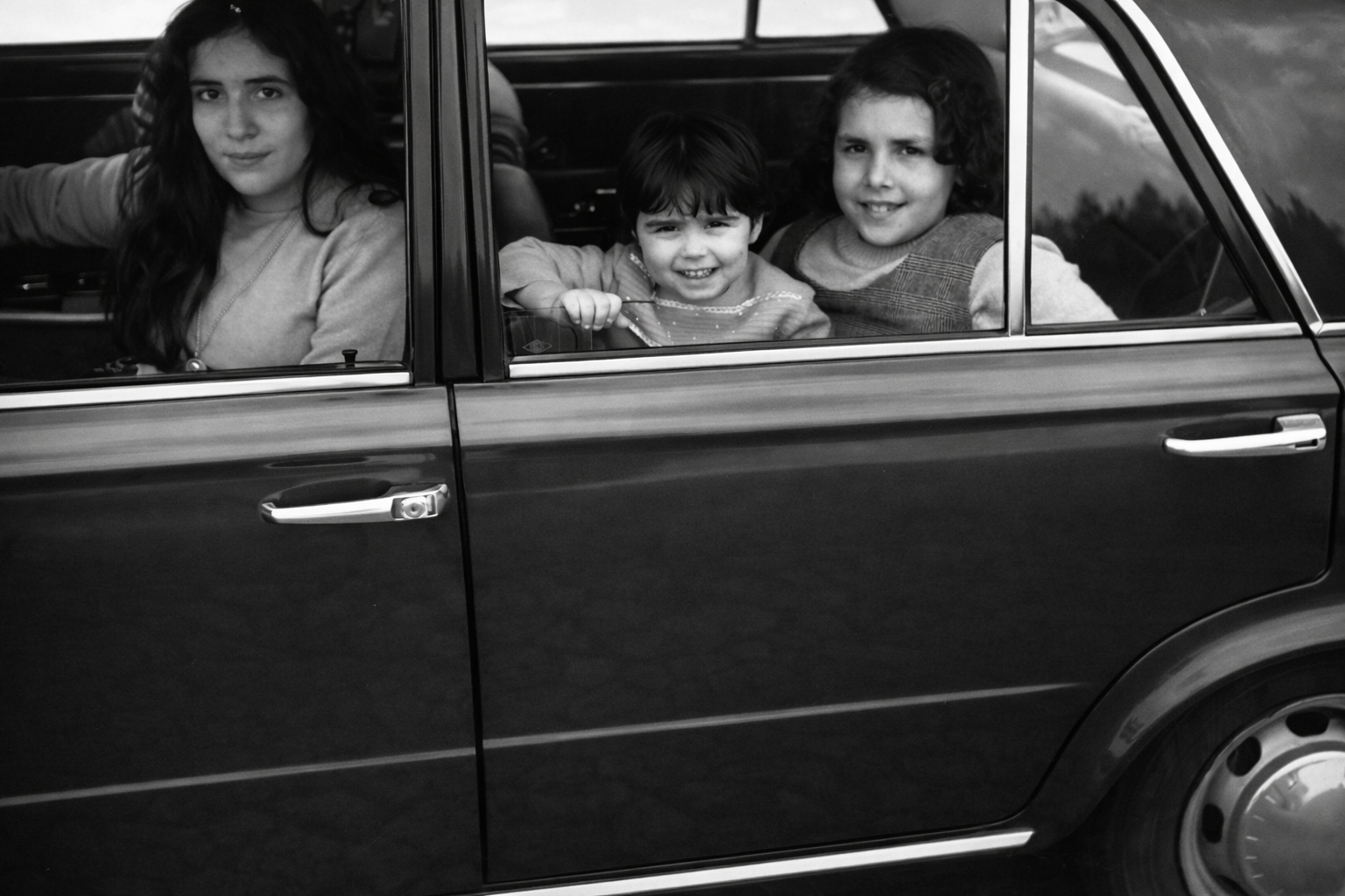 Crianças sorridentes no carro antigo