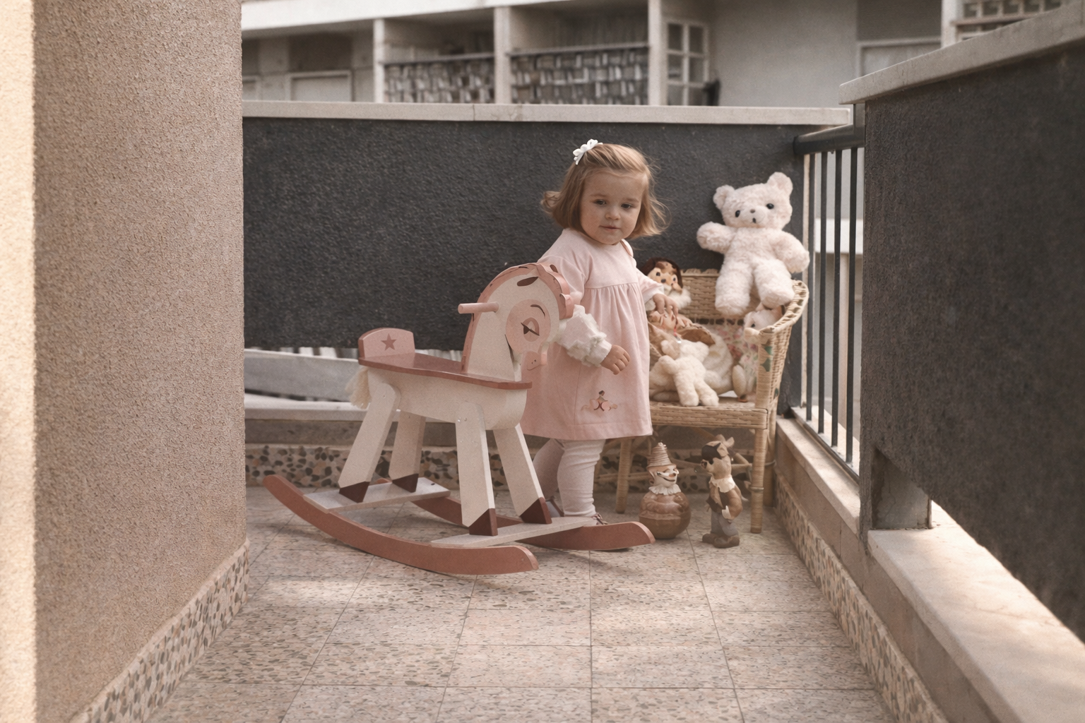 Menina com brinquedos no varandim