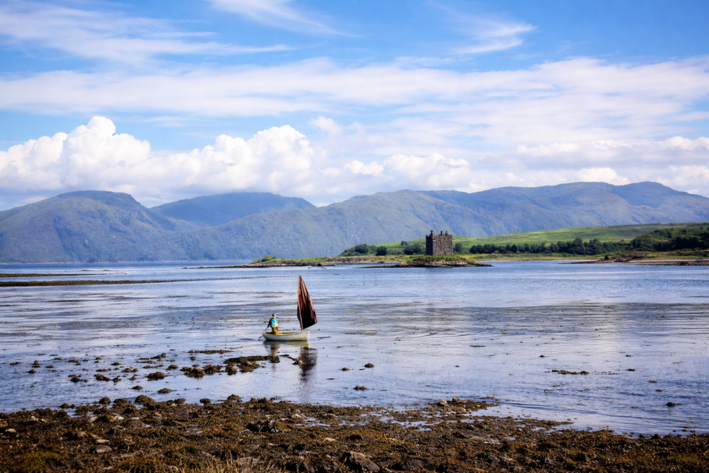 Barco à vela e castelo nas Highlands