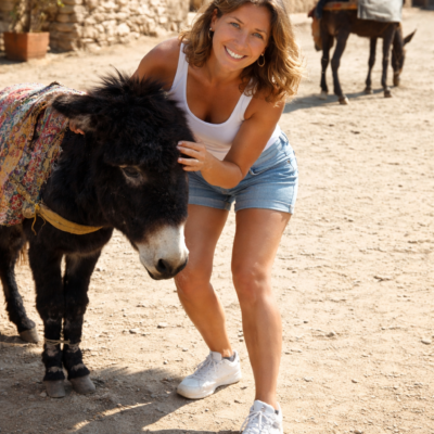 Mulher acariciando um burro no campo