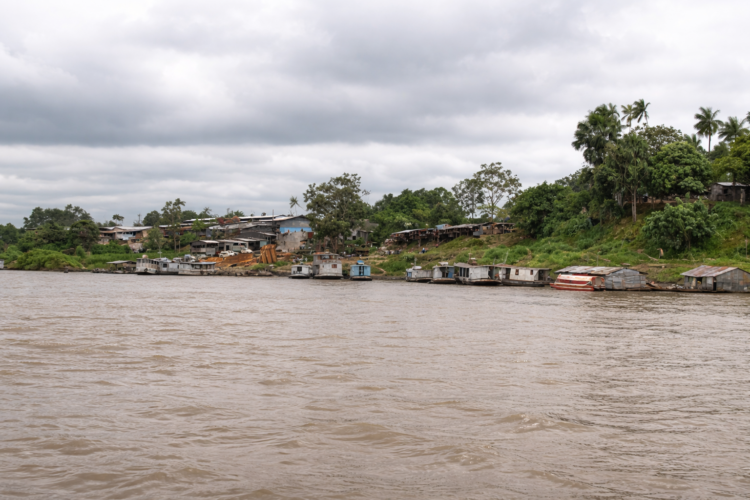 Vila ribeirinha sob céu nublado