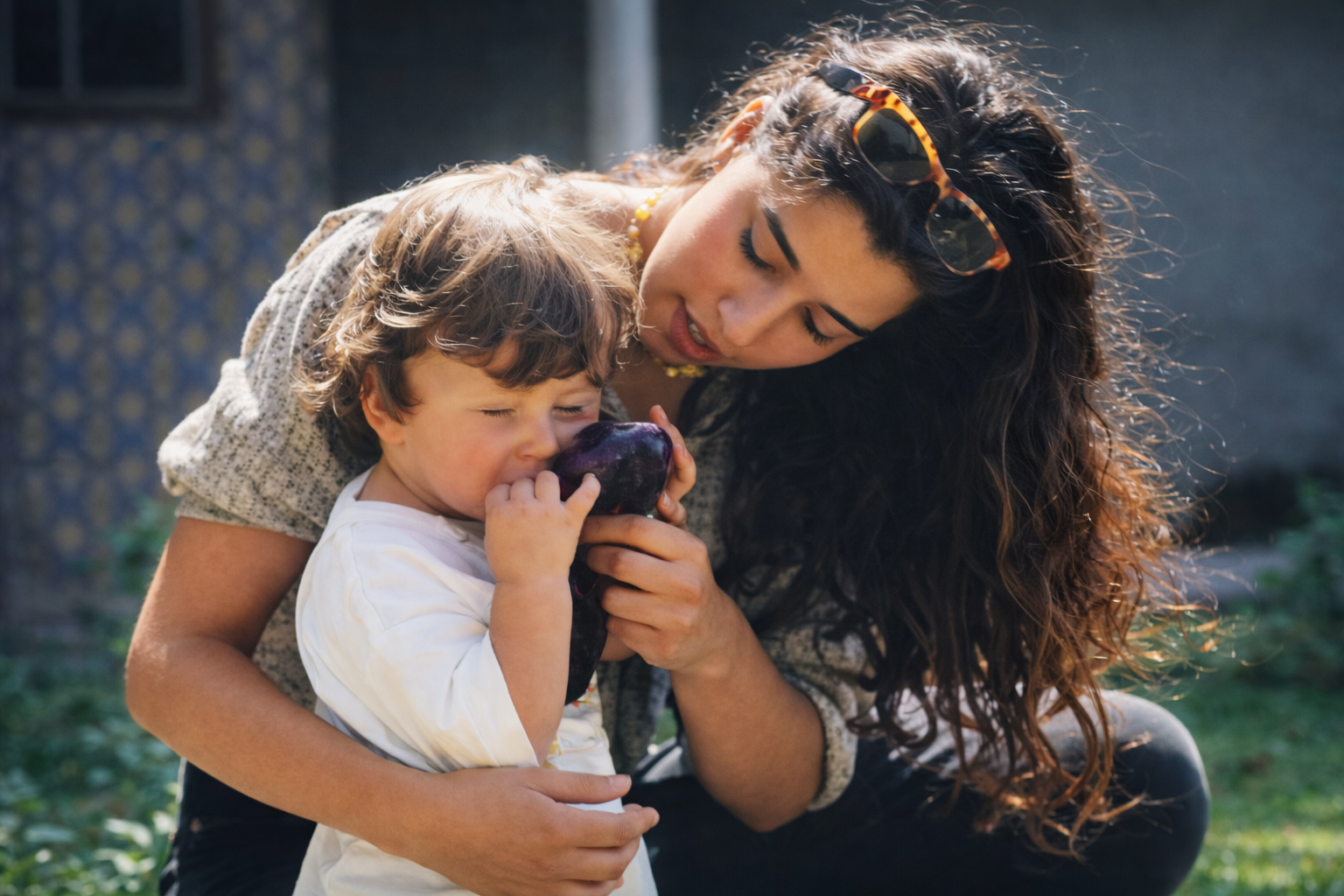 Mãe e filho com fruta roxa