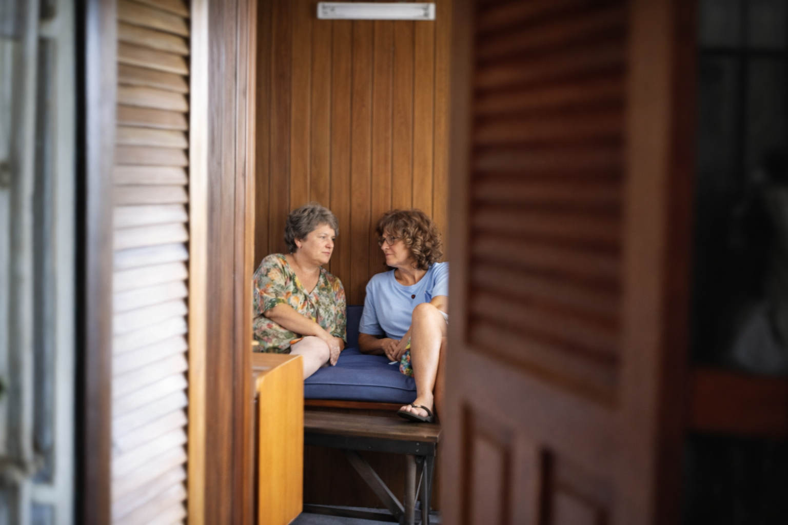 Mulheres em conversa através de persianas
