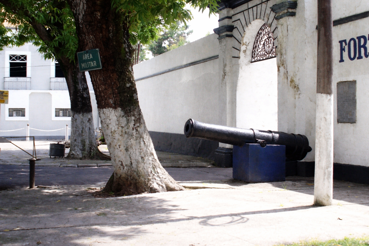 Canhão à sobre de sombra da árvore no quartel