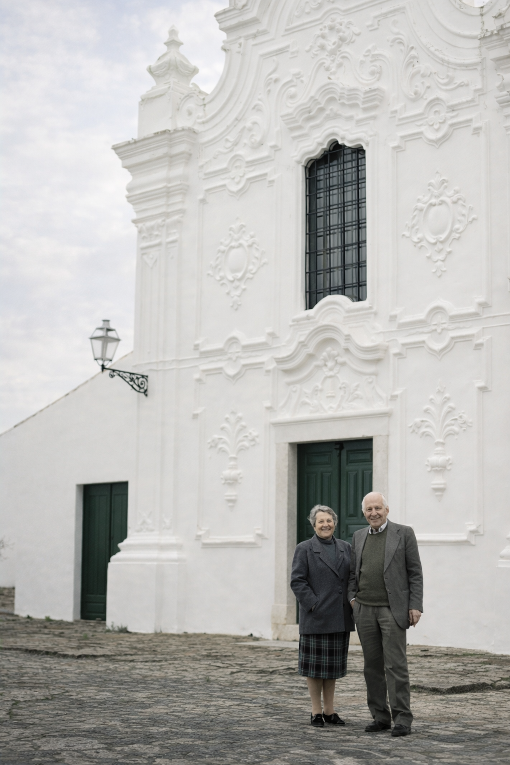 Casal idoso em frente à igreja barroca