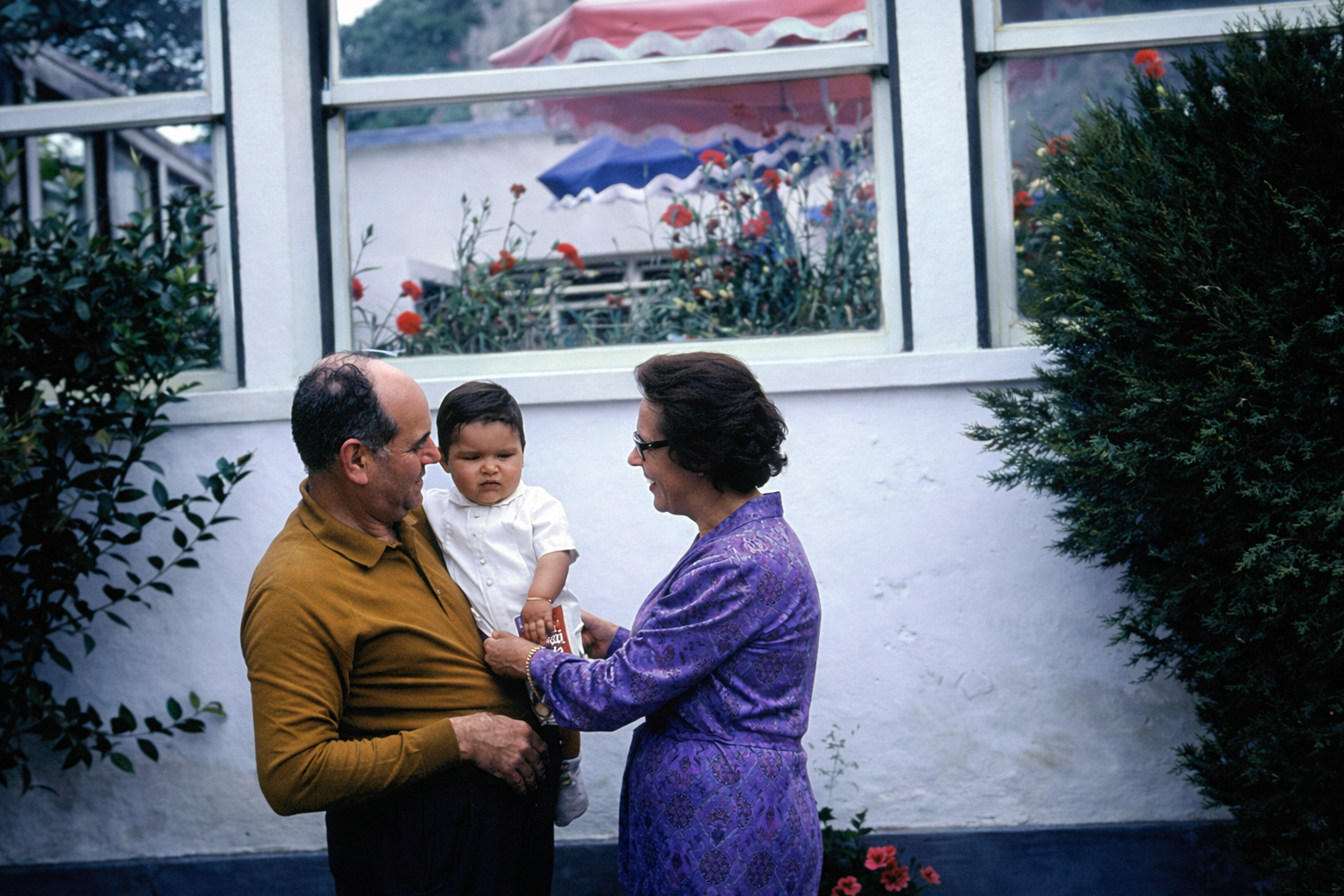 Família ao ar livre frente ao edifício branco