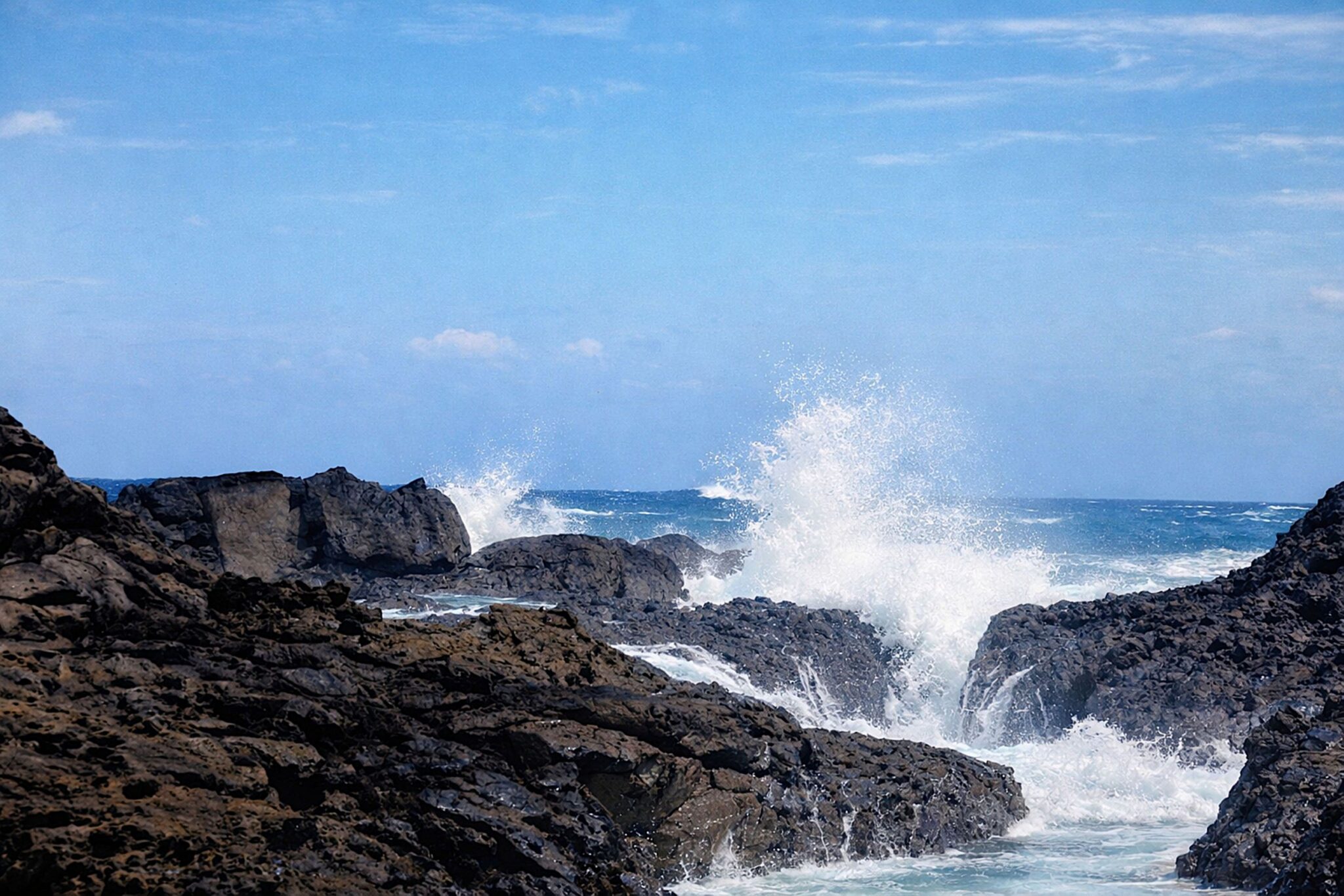Ondas a bater nas rochas vulcânicas