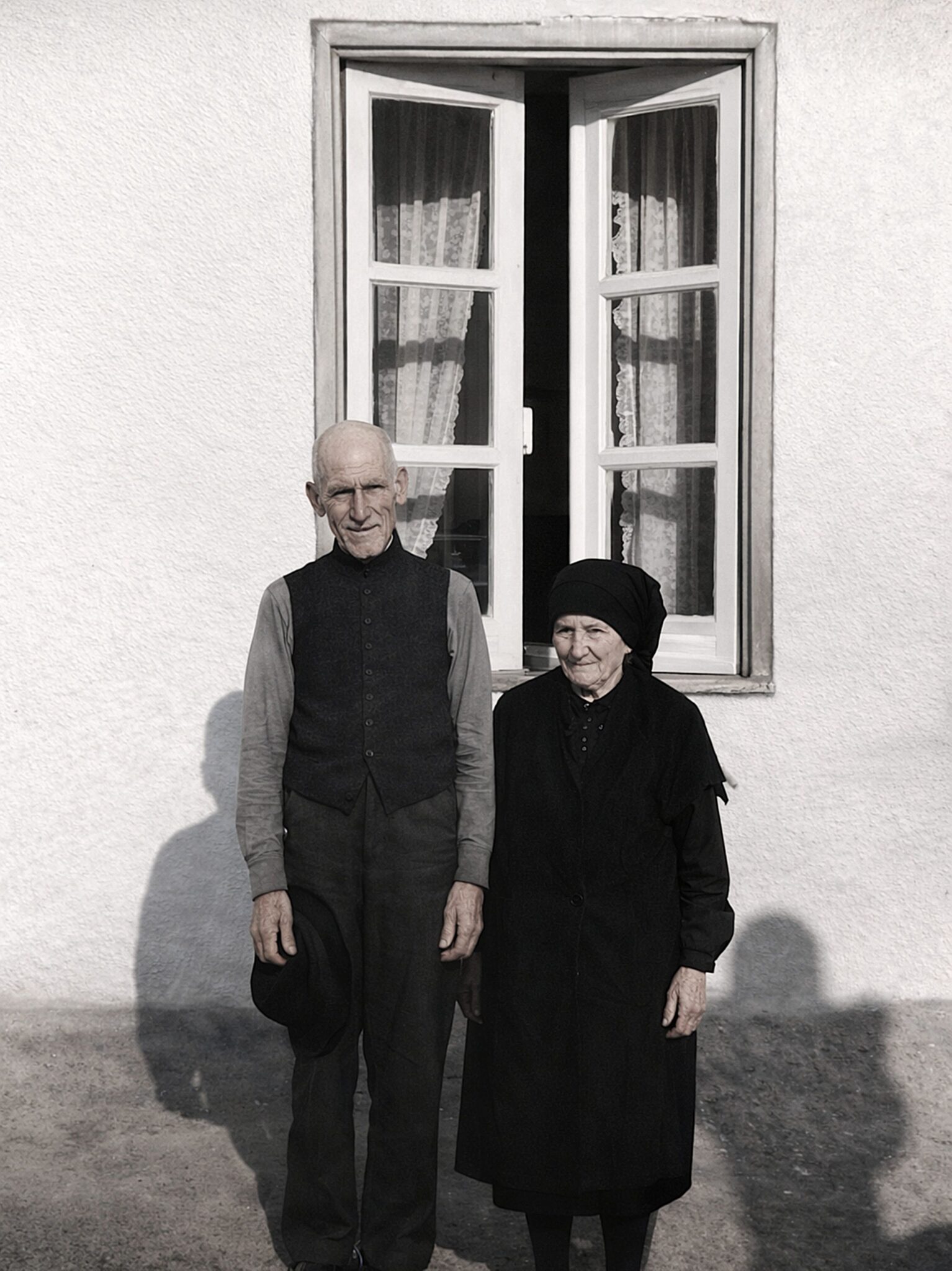Casal envelhecido em frente à casa branca