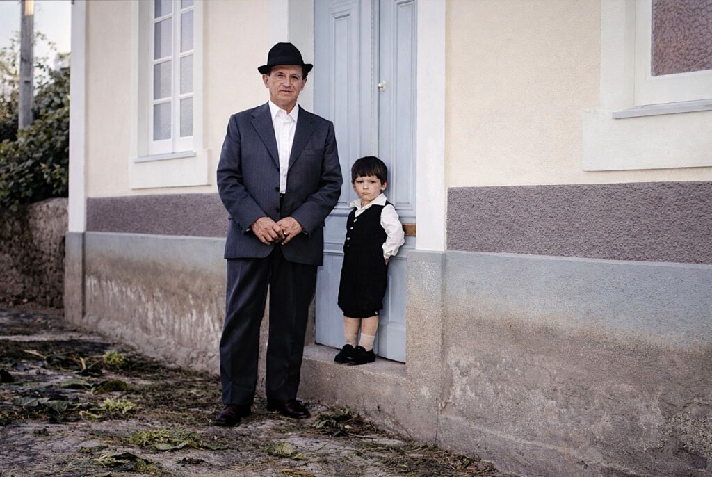Homem e criança em frente à casa