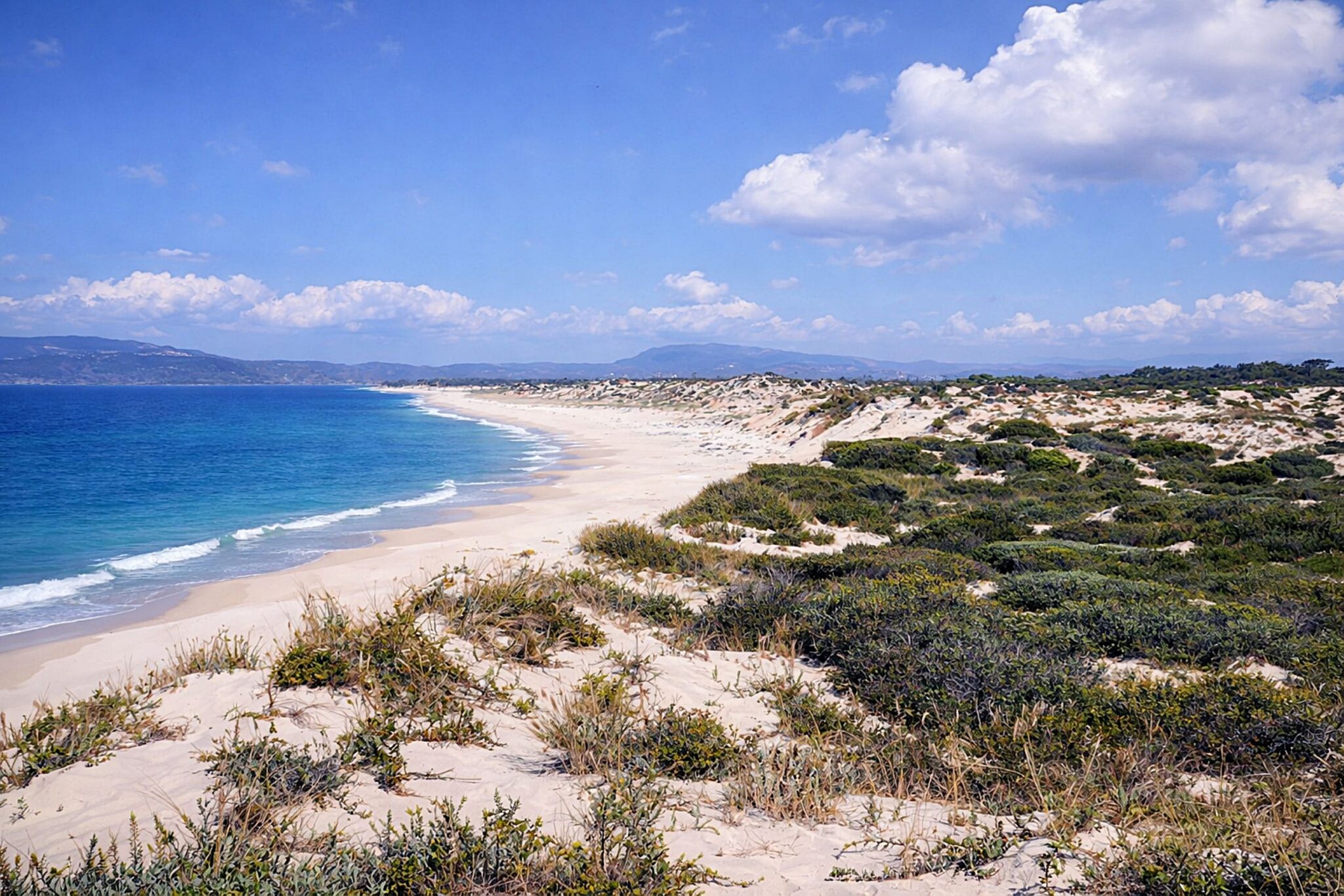 Praia tranquila com dunas e oceano