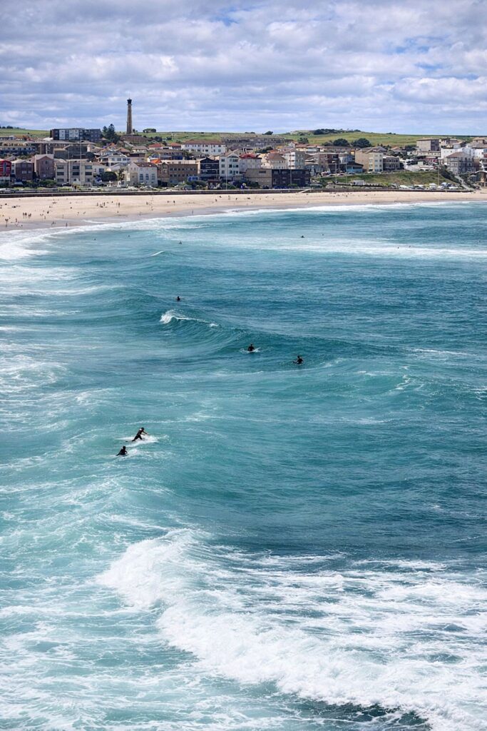 Surfe na costa e farol ao fundo