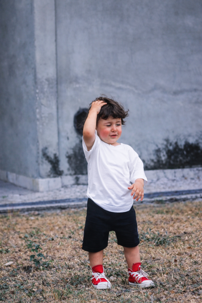 Menino curioso diante de muro gasto