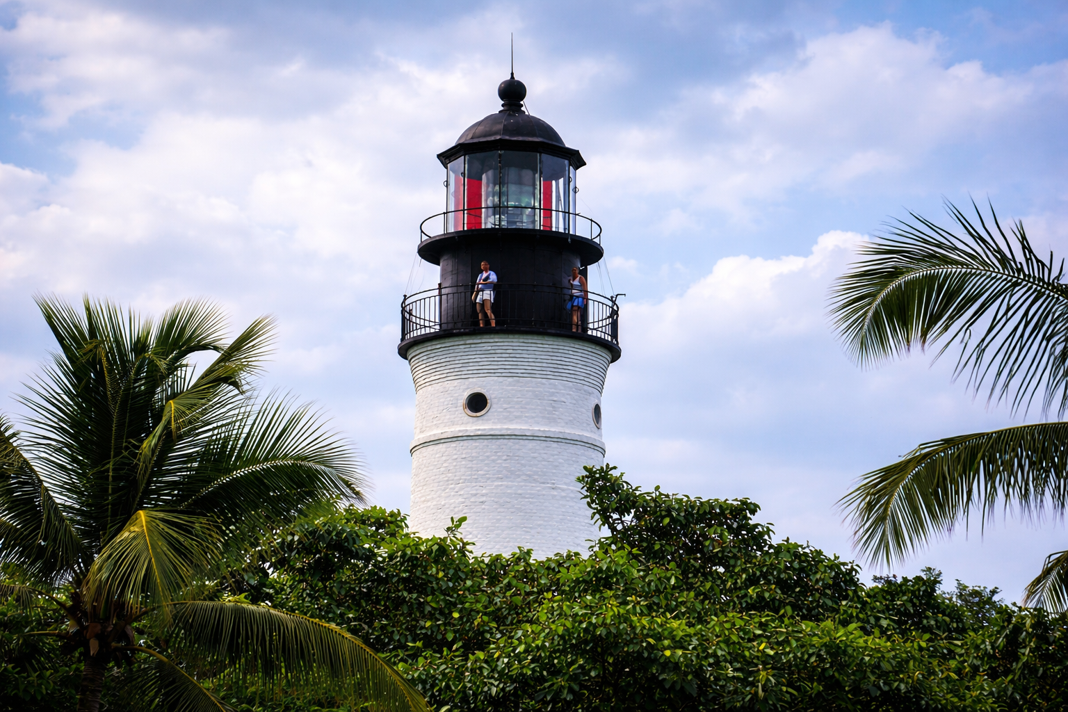 Farol branco rodeado por vegetação tropical