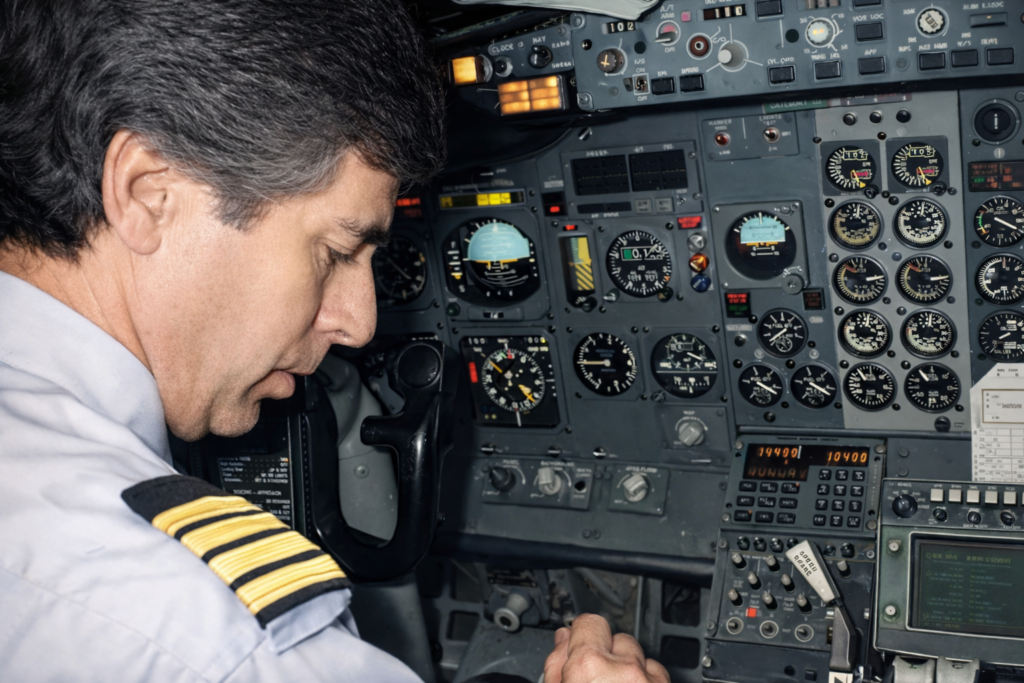 Piloto no cockpit ajustando instrumentos