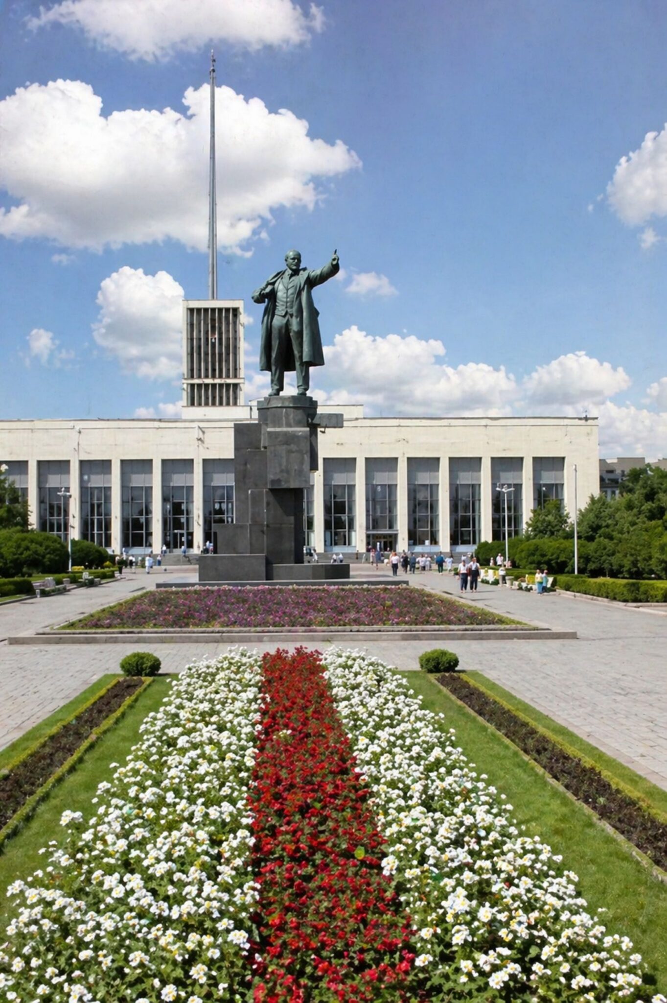 Praça monumental com estátua e flores