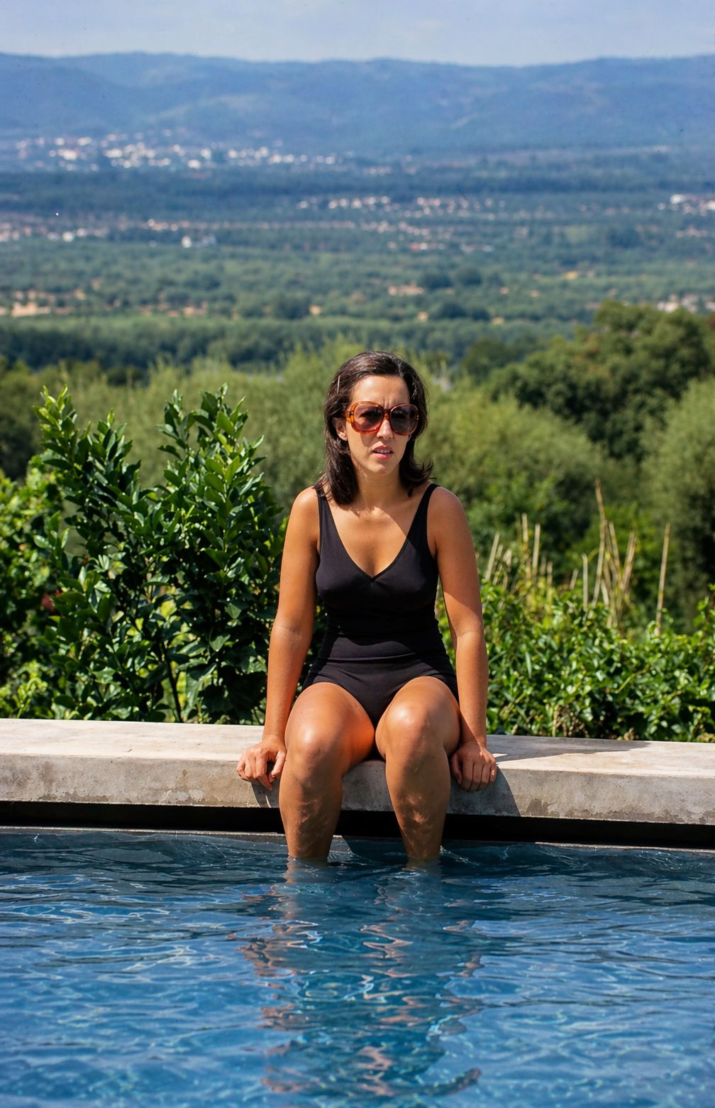 Mulher à beira da piscina ao sol