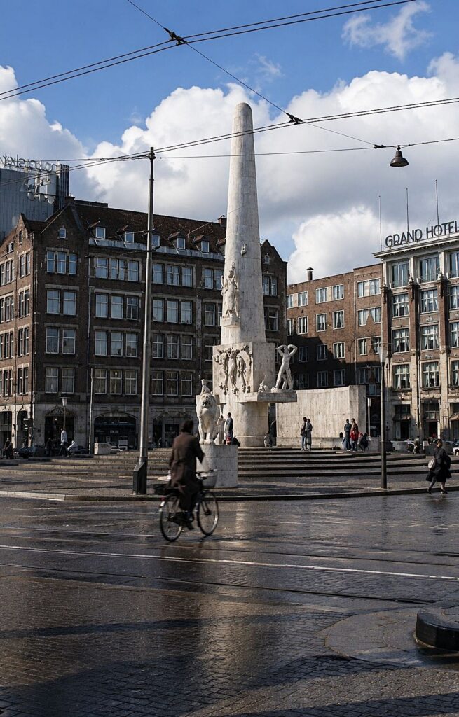 Praça urbana com monumento e ciclista