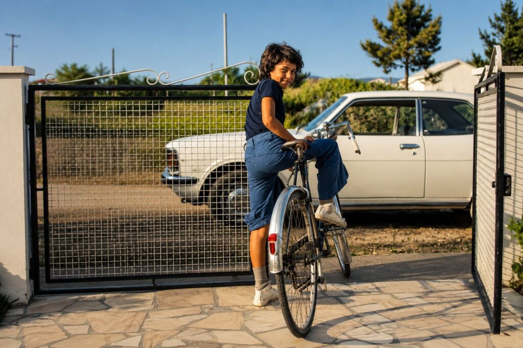 Criança sorridente a pedalar no portão