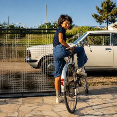 Criança sorridente a pedalar no portão
